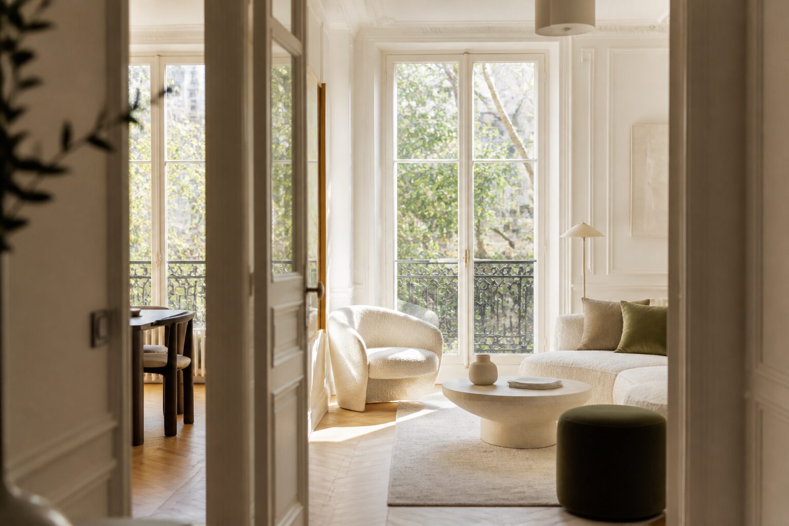 Salon lumineux d'un appartement rénové à Rueil-Malmaison, parquet clair et grandes fenêtres
