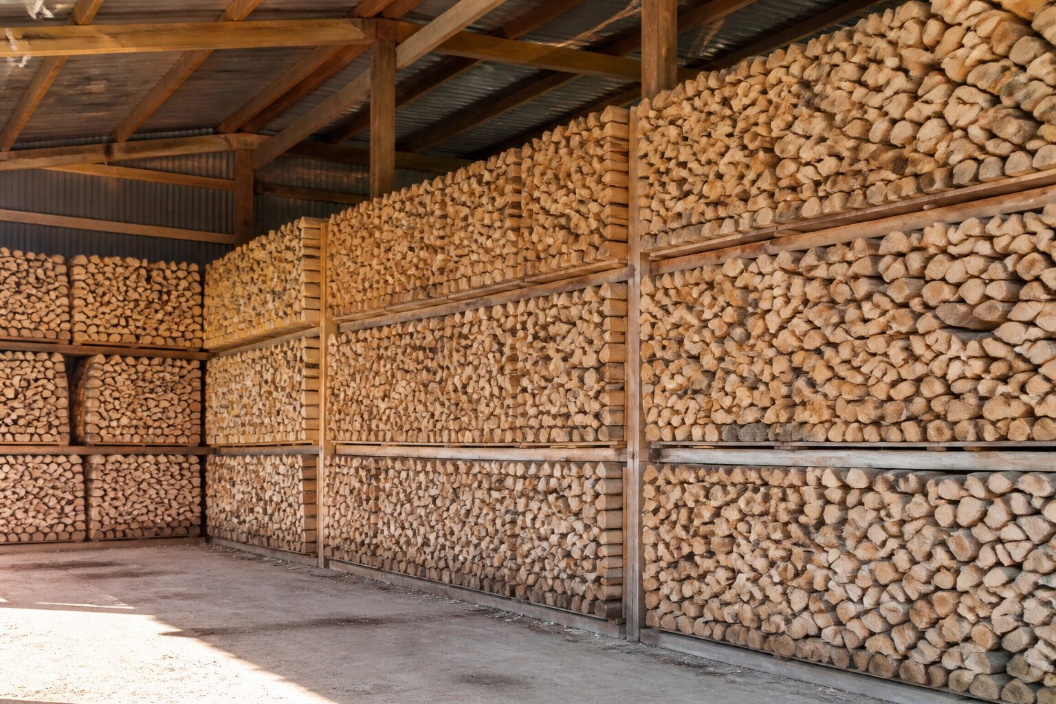 Stères de bois de chauffage en 50 cm empilés dans un hangar agricole