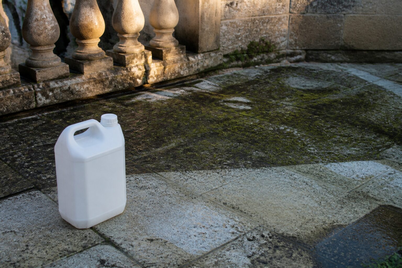 J.Net Gros Travaux bidon 5 litres sur une terrasse en pierre en cours de nettoyage