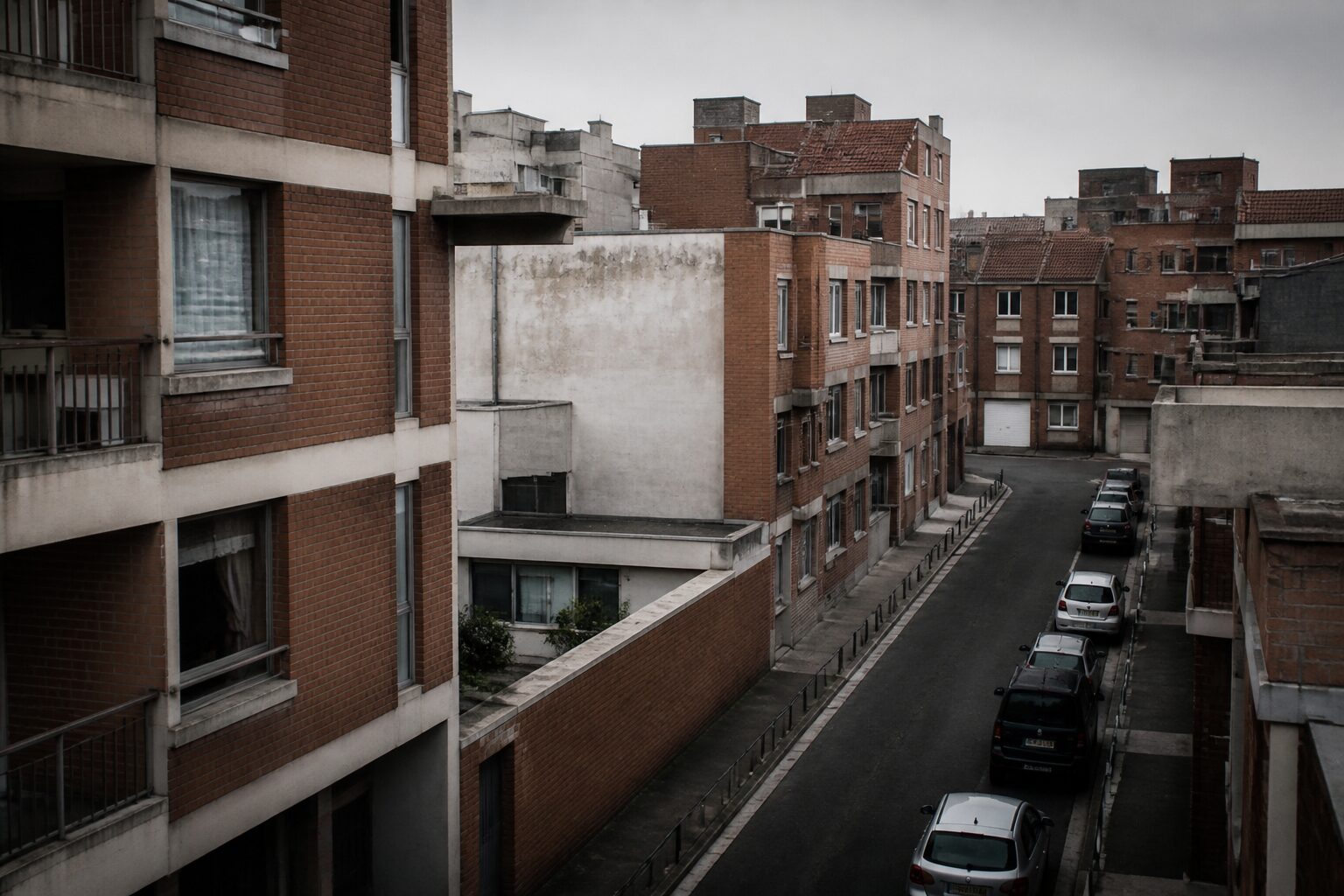 Vue urbaine de Dunkerque, rue pavée sous ciel gris du Nord avec immeubles en briques