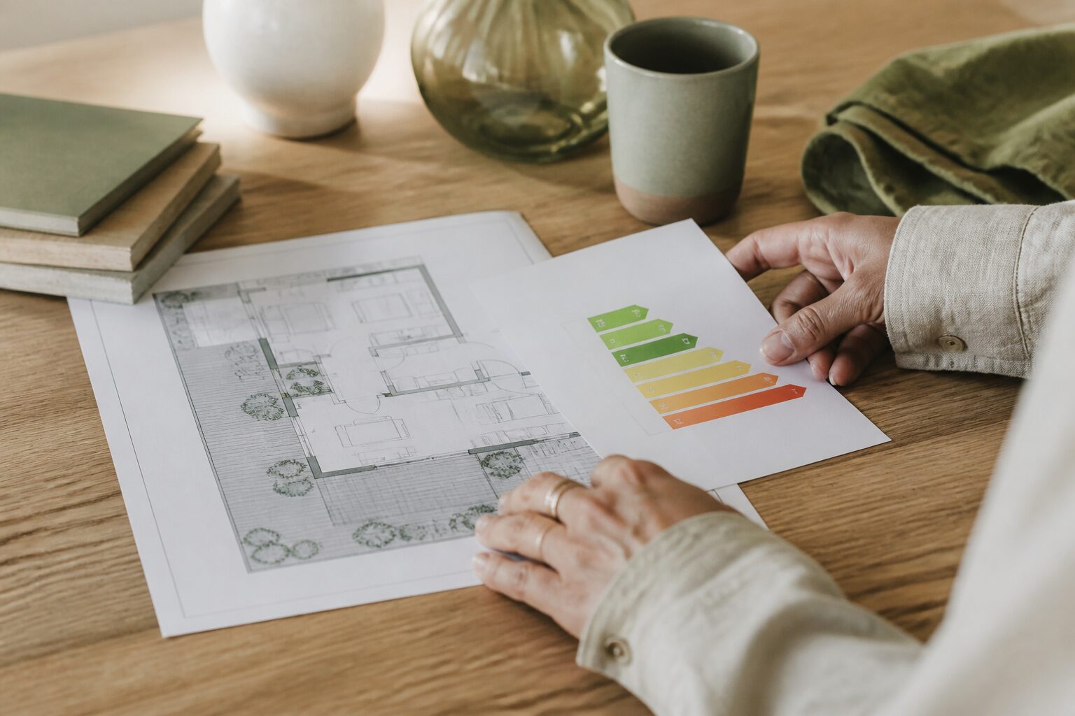 RSE immobilier au concret : mains examinant un plan de rénovation et une étiquette énergie