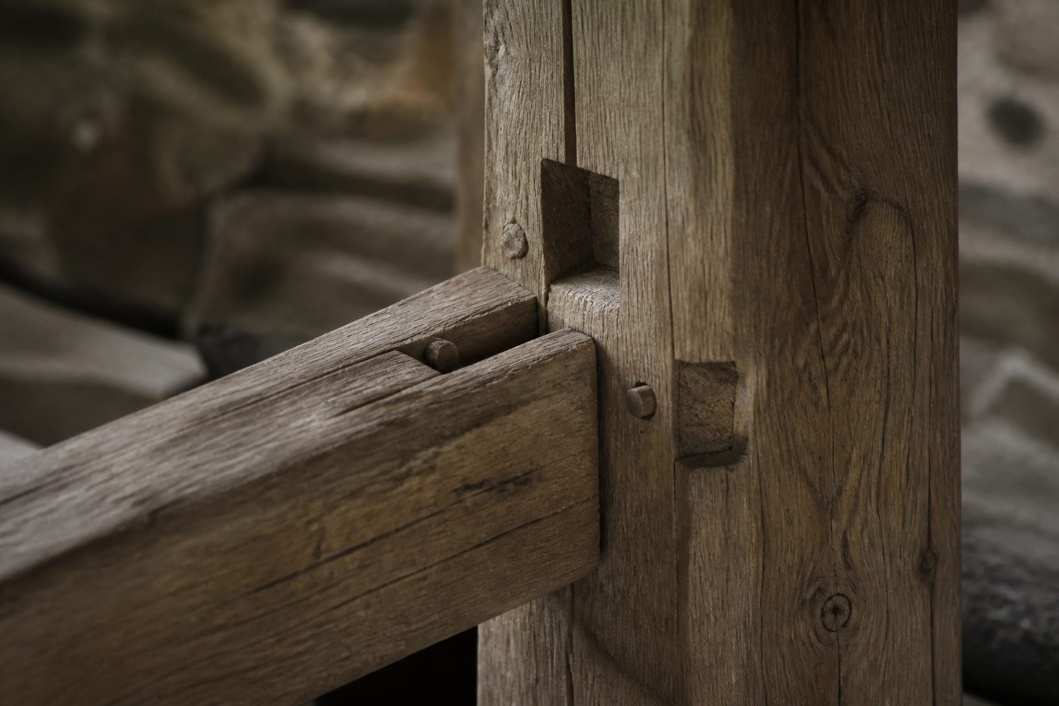 Détail d'un assemblage tenon-mortaise sur une charpente en bois traditionnelle, gros plan sur les encoches et les chevilles en bois