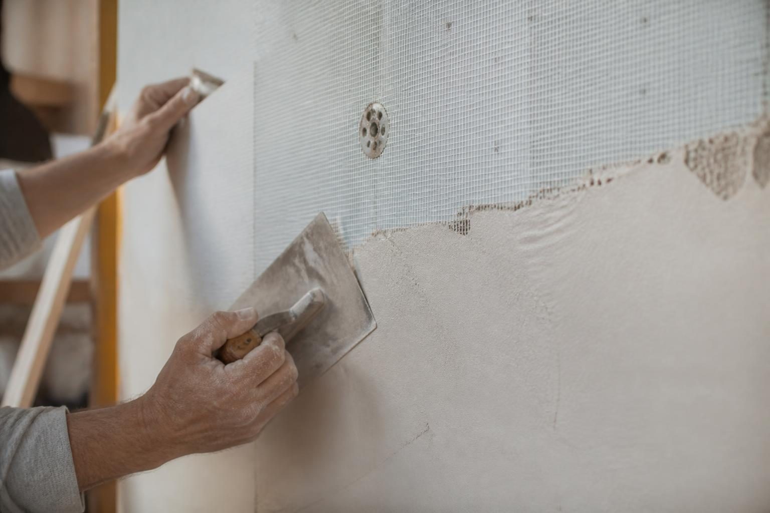 Détail d'un mur avec isolant et enduit de finition en cours de pose