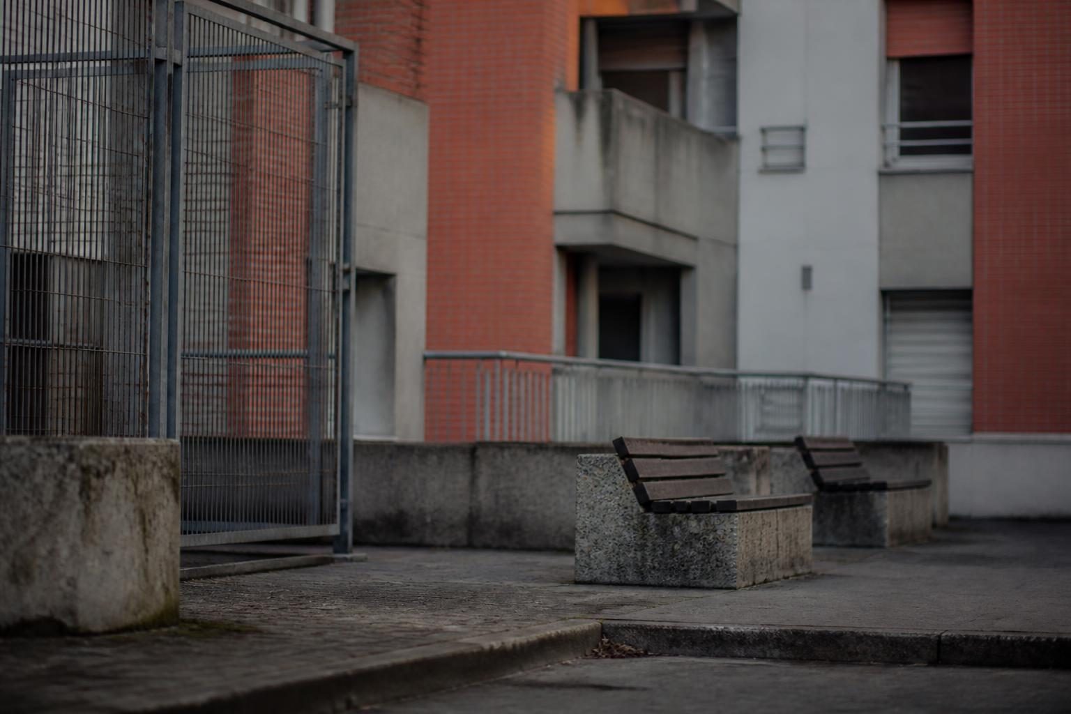 Cour intérieure de logements collectifs à Hérouville-Saint-Clair, béton et grillages en lumière froide
