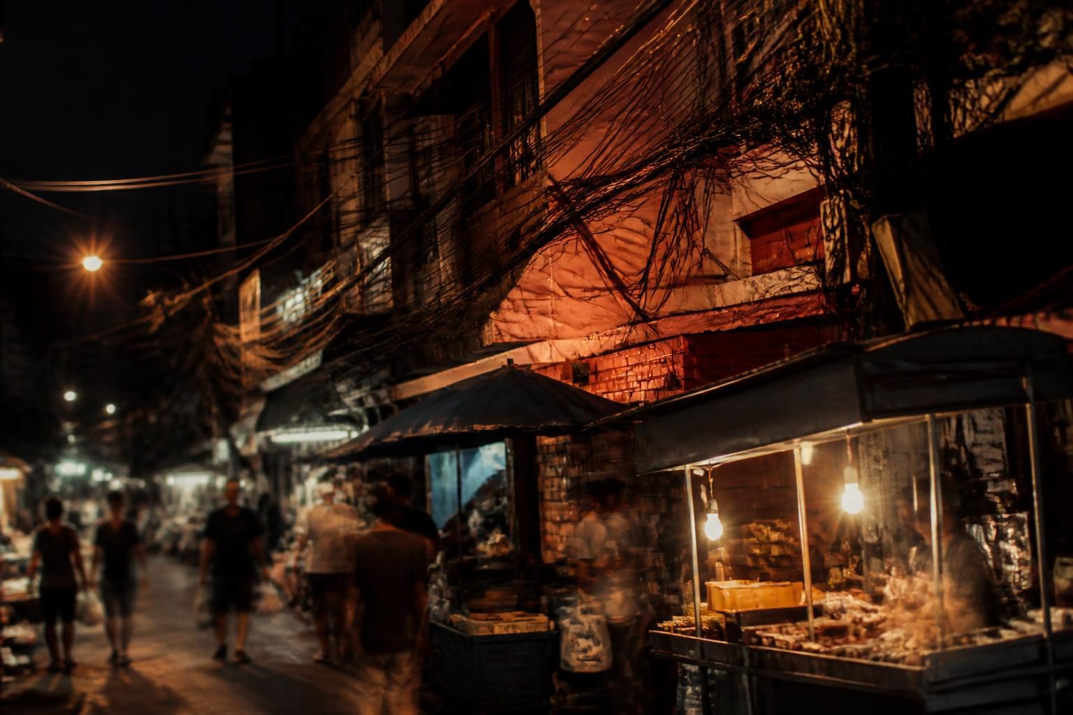 Ruelle animée d'un quartier populaire de Bangkok le soir