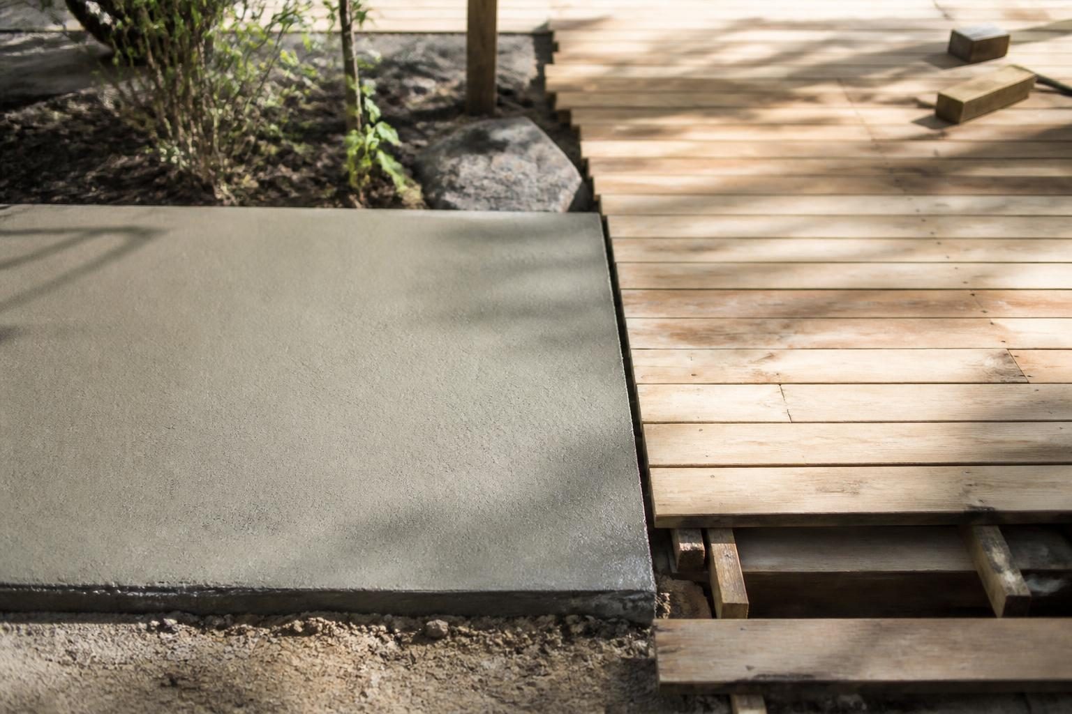 Dalle béton coulée en renfort sous une terrasse en bois destinée à porter une piscine
